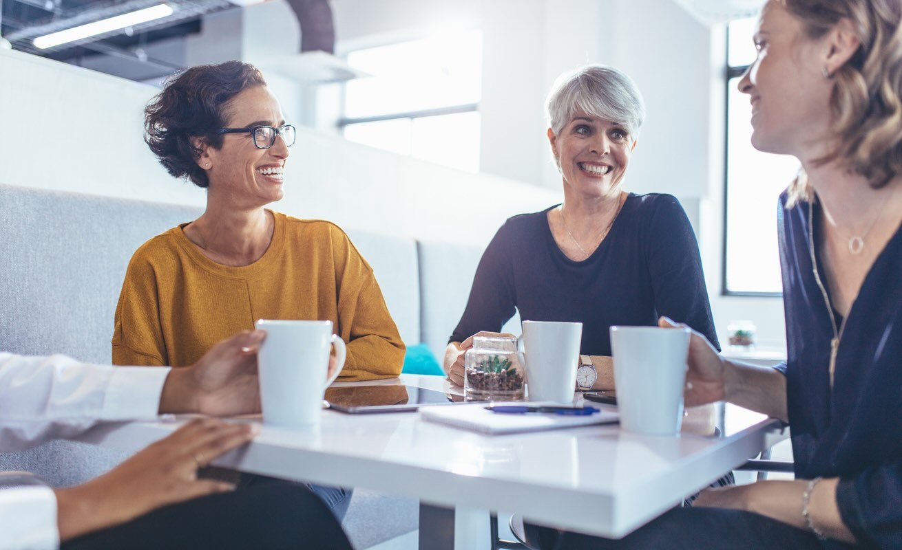 Team of corporate professionals having casual discussion at office. Multi-ethnic business group during coffee break in office.