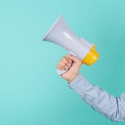 Male Hand is hold megaphone and wear blue shirt on green or mint or Tiffany Blue background.